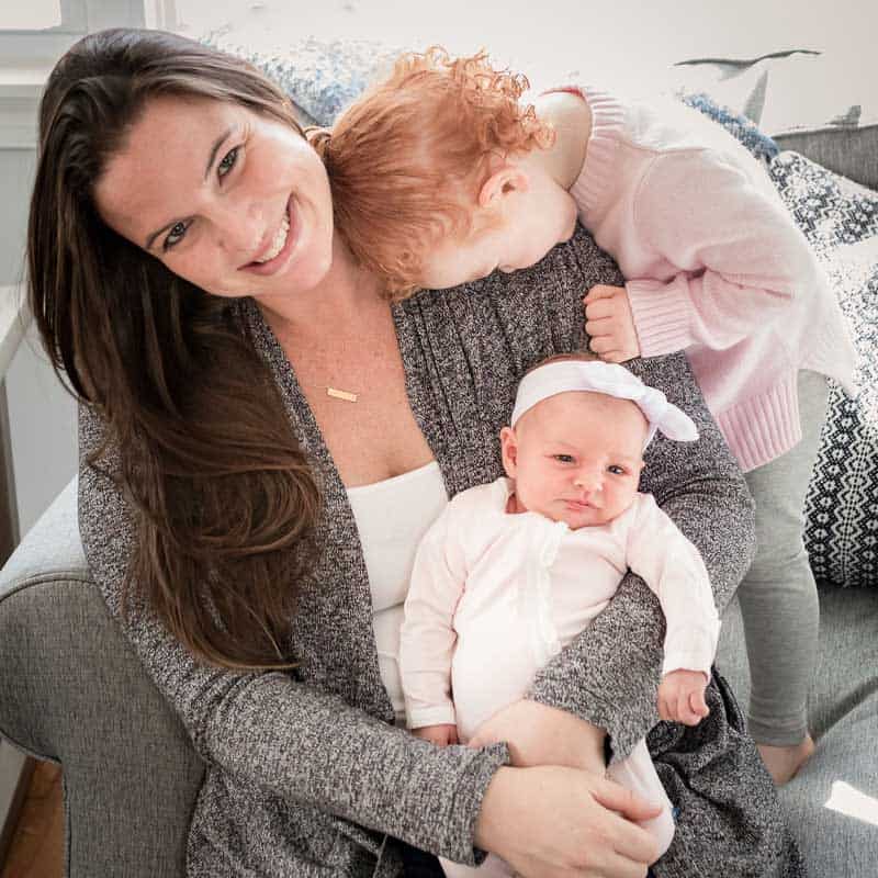 Nanny laughing while holding two children