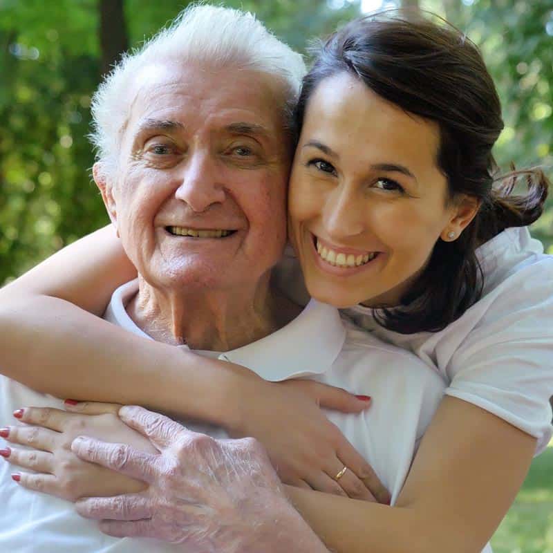 Caregiver and elderly man smile