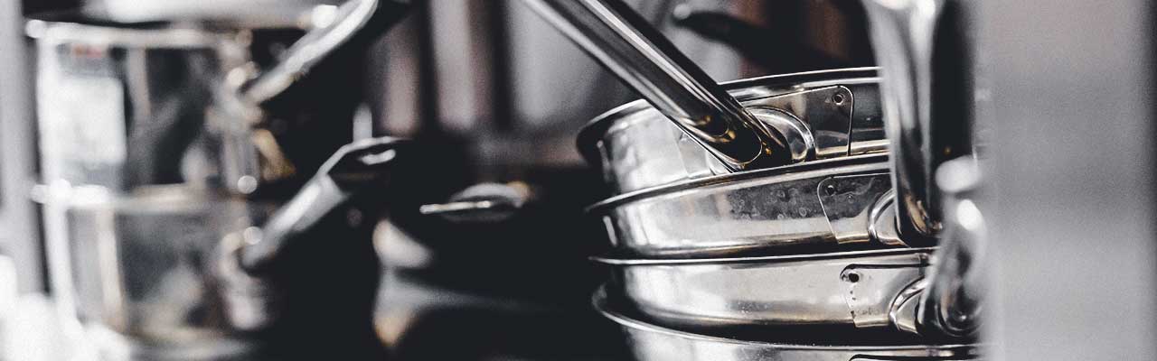 A stack of chrome cooking pots and pans