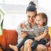 A nanny reads a tablet with a small child | Household Staffing