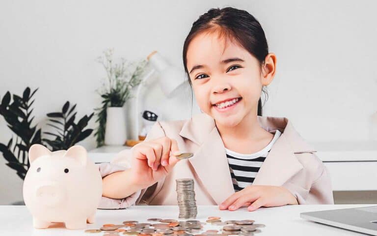 A girl tallies up money from a piggy bank | Household Staffing