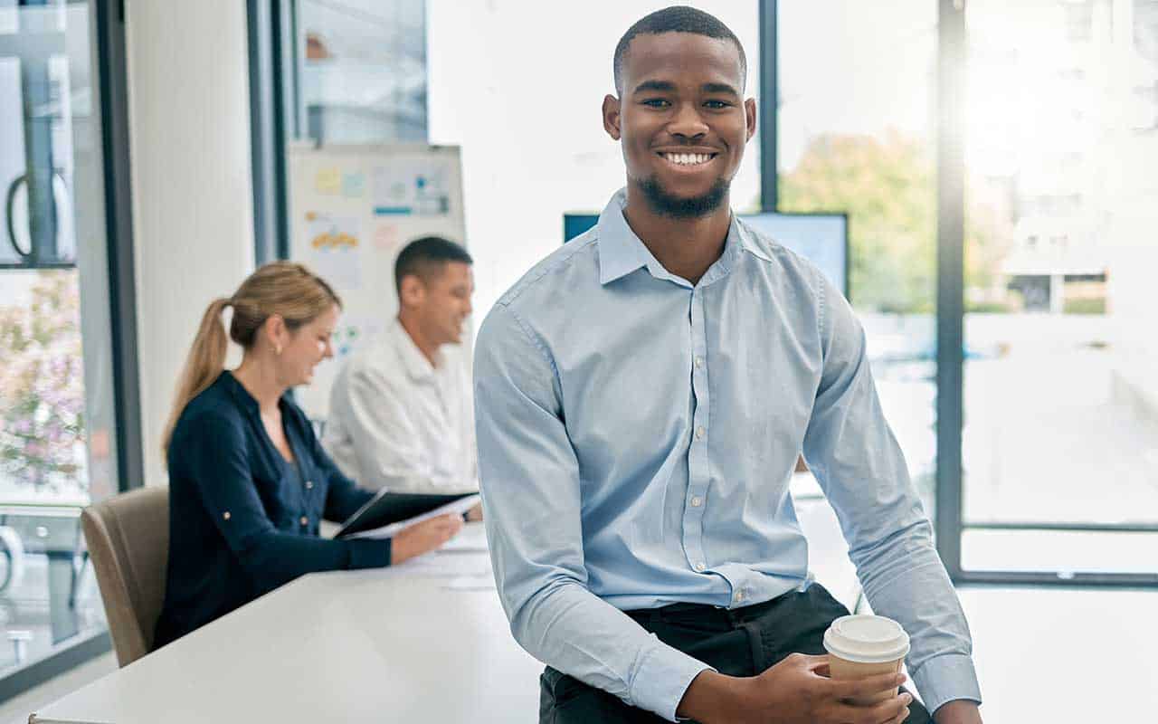 An executive assistant smiles while standing in a domestic employer’s office | Household Staffing