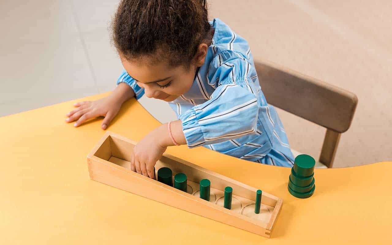 Young child independently pouring water using Montessori materials | Household Staffing 